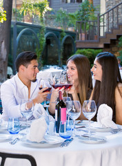 Handsome man toasting with two beautiful women.