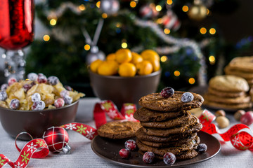 freshly baked chocolate chip cookies on a table with blurred christmas tree background.