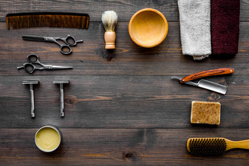 Fototapeta na wymiar Vintage barbershop tools. Razor, sciccors, brush on dark wooden background top view pattern copyspace