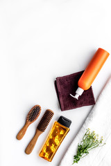 Women hair care set. Comb, shampoo, spray, towel on white background top view copyspace