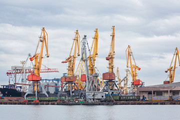 Fototapeta premium Lifting cargo cranes, ships and grain dryer in Sea Port of Odessa, Black Sea, Ukraine.