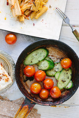 Fresh and ripe vegetables - tomatoes and cucumbers, roasted on fry pan.