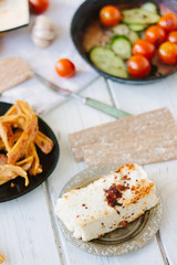 Big piece of tofu - vegan cheese, roasted. With vegetables and other food.