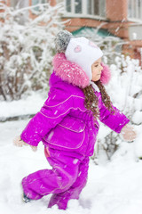 Little kid girl on snowy winter day outdoor.