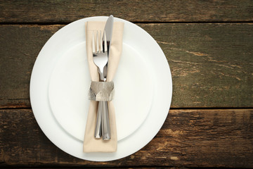 Fork and knife with napkin on white plate