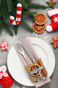 Kitchen cutlery with plate and christmas decorations on wooden table