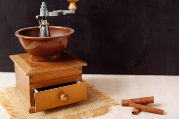 Coffee grinder old on a wooden table and black background.