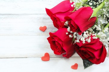 Valentine's day background with red roses on white wooden frame, selective focus
