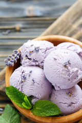 Homemade lavender ice cream in a wooden bowl.