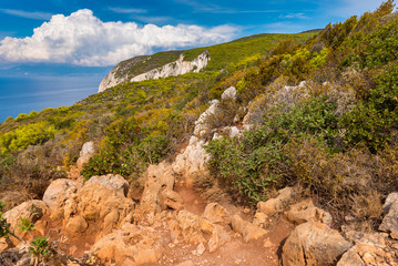 Rocks and dry grass on seaside cliff. Beautiful view of sea waters and coast on Zakynthos island Greece.