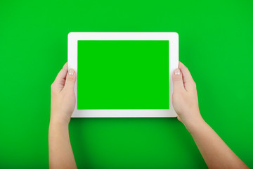 female hands hold a white tablet with a blank screen