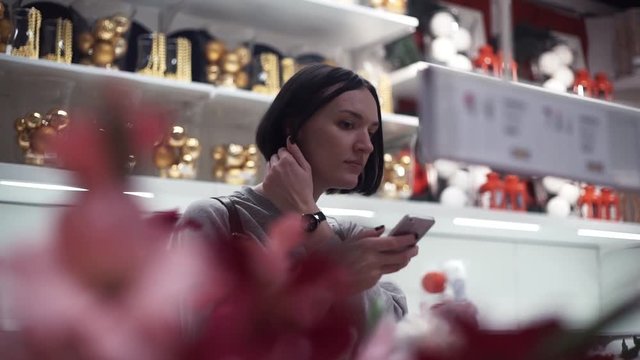 Young girl taking photo using smartphone in store with household products