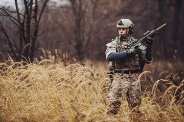 soldier with rifle in full gear. Military man on the background of nature.