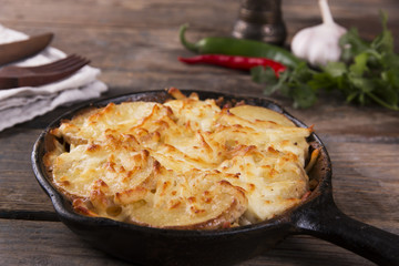 potato casserole with cheese in a frying pan serving vegetarian dish homemade