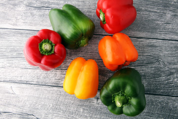 Red, green and yellow sweet bell peppers on table.