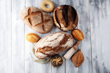 Fototapeta premium Different kinds of bread and bread rolls on white board. Kitchen or bakery poster design