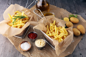french fries, chips on wooden background with salt