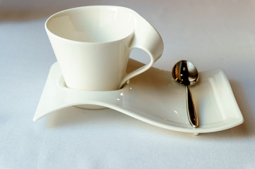 designer white Cup on a saucer with a teaspoon
