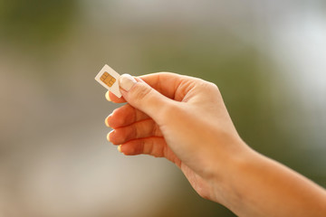 female hand holding white SIM card 
