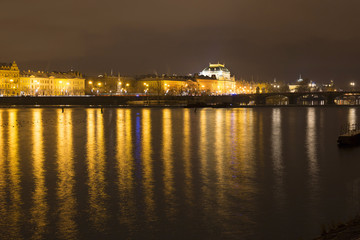 Fototapeta na wymiar View on the night snowy Prague National Theater above River Vltava, Czech Republic