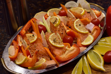 Raw salmon with vegetables prepared for baking.