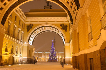 The historical architecture of the Arch of the General Staff   and a Christmas tree on the main Palace Square of St. Petersburg on a winter night in snow. Arch of the General Staff, Palace Square and  - obrazy, fototapety, plakaty