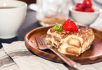 Homemade tiramisu cake decorated with strawberries Italian cuisine, Selective focus