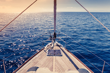 Ship's Bow, sailing yacht deck with open sea and warm sunlight