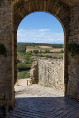View of the tuscany hills from an arch of the walls of the ancient hamlet of Monteriggioni