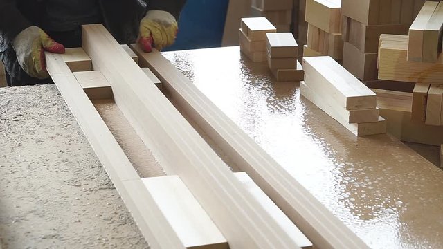 industrial carpenter worker operating wood cutting machine during wooden door furniture manufacturing