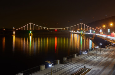 Fototapeta na wymiar Night landscape. The city of Kiev, Ukraine, Europe. Pedestrian bridge across the Dnieper River.