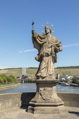 Fototapeta na wymiar Baroque Statue of Saint John of Nepomuk, designed in the 18th century, Wurzburg, Franconia, Bavaria, Germany. This sculpture is standing at the old bridge over the River Main
