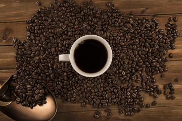 Cup of coffee and coffee beans on old wooden background. Directly above.