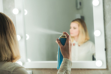 Pretty young woman styles her hair