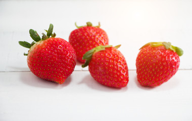 The red strawberry put on timber board,blurry light around.