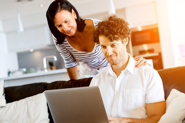 Couple at home using laptop