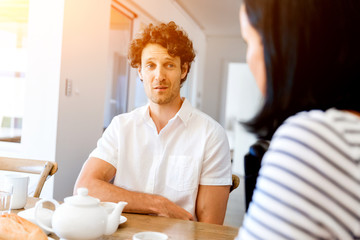 Portrait of man sitting and talking to woman indoors