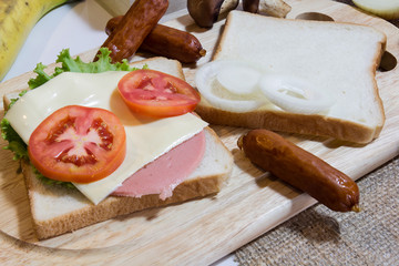Sandwiches, tomatoes, ham, cheese, onion and hot dog