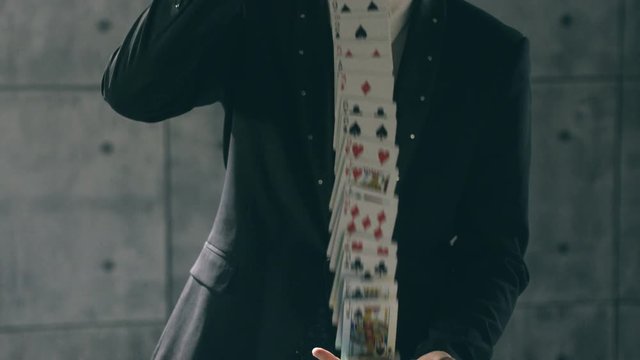 Hands of illusionist performing card trick