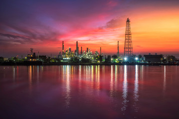 Naklejka premium Oil and gas industry - refinery at Sunrise - factory - petrochemical plant with reflection over the river