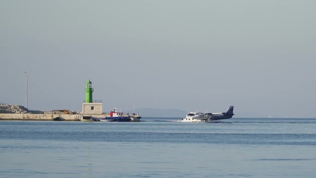 Harbour Hydroplane slides on waves when dangerous sea traffic situation. Pirce with green sea beacon