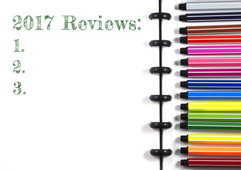 2017 Reviews text on white sketchbook with color pen, top view