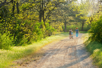 Fototapeta premium Two women with a child strolling through in the park