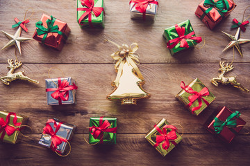 Top view of golden Christmas tree and many gift boxes placed on wooden floor.
