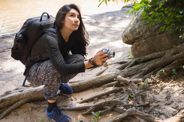 Asian woman backpack taking a photo with mirrorless camera