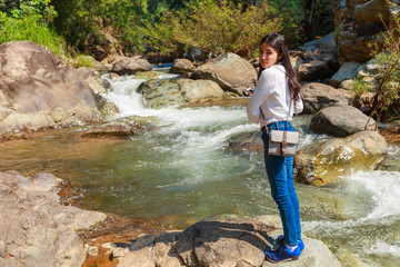 Woman hiking around mountains near the river at spring time.