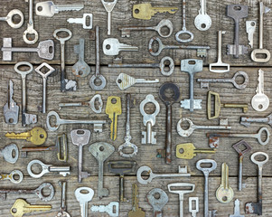 set of rusty old keys on gray wooden rustic boards. flat view.