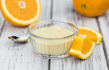 Wooden table with orange fruit powder (selective focus)