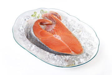 A closeup view of a raw salmon steak on ice
