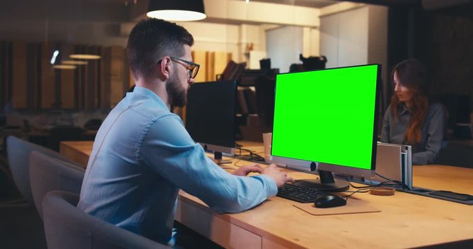 Man and woman colleagues professionals communicating while working together in modern office. Green screen chroma key. 4K UHD
